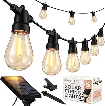 Brightech Ambience Pro solar string lights with warm Edison bulbs hung over an outdoor patio at dusk